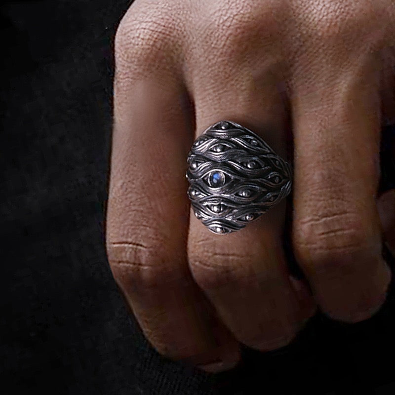 finger with silver ring with eye forest