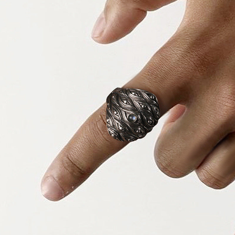 finger with silver ring with eye forest