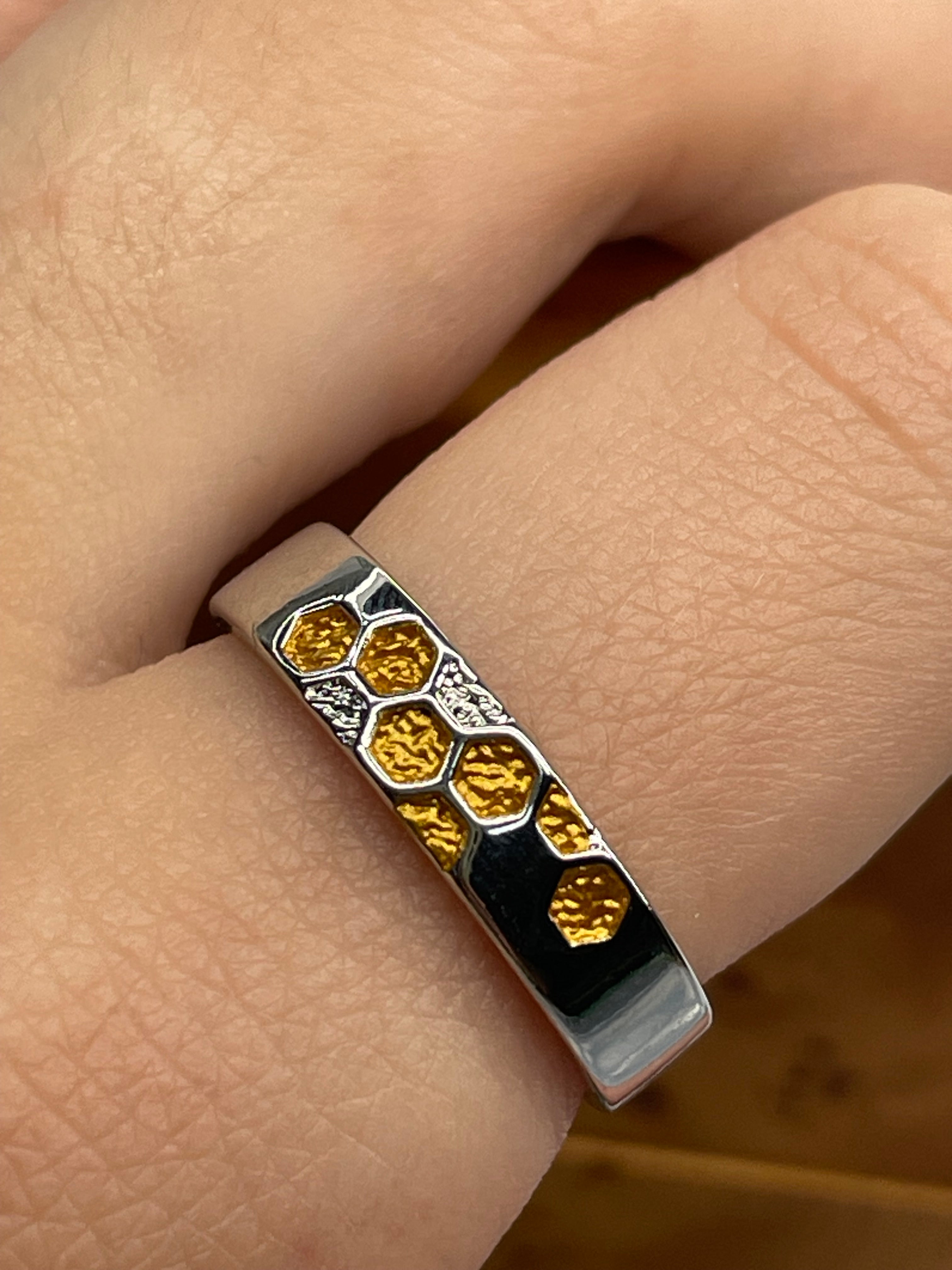 finger with silver bee hive ring with gold plated design
