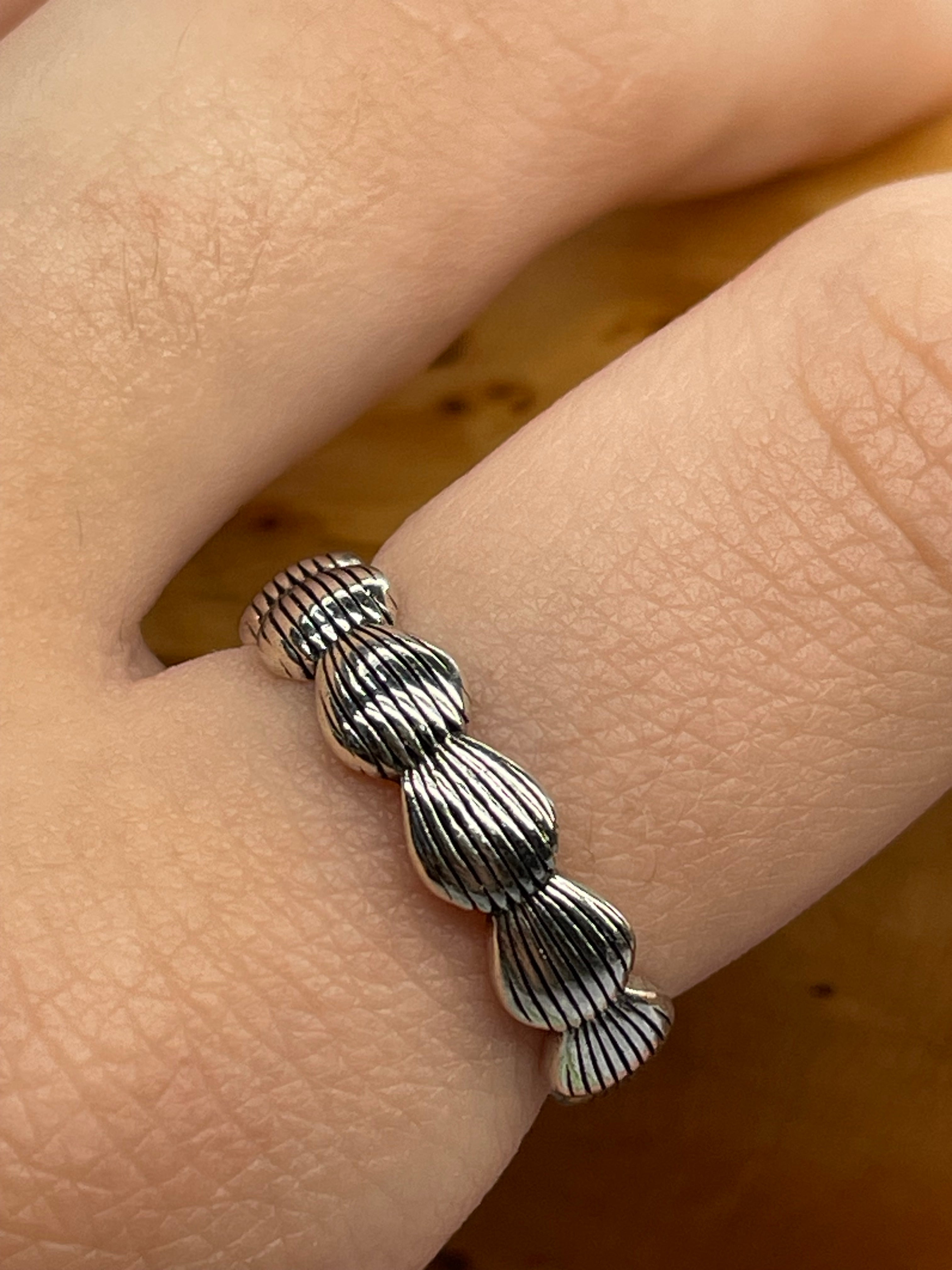finger with silver sea shell ring