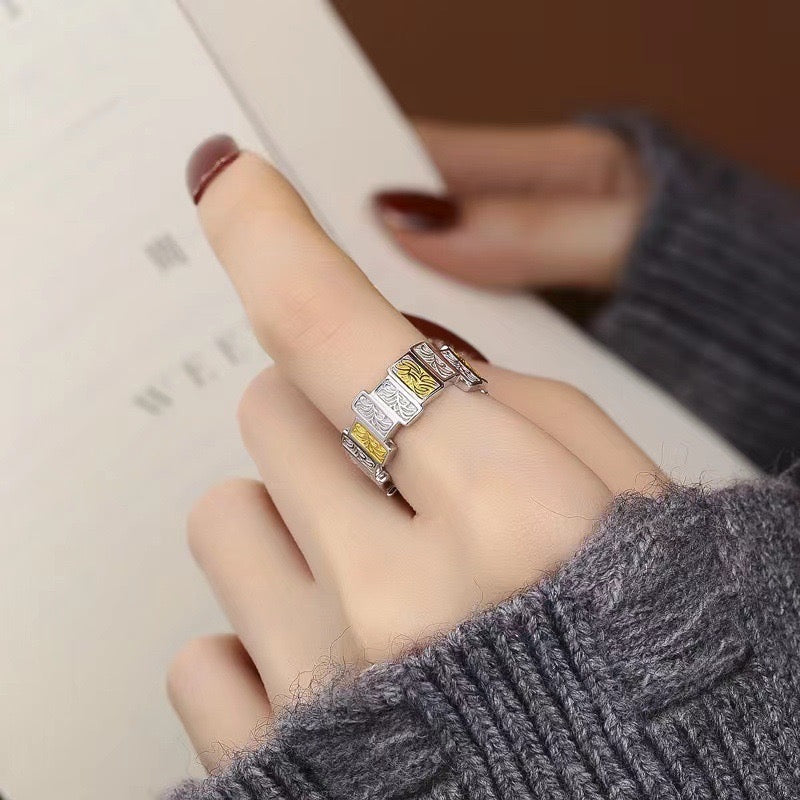 finger with silver tile ring with gold plated details