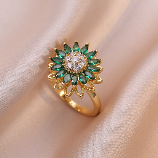 gold fidget ring with green zircon flower design