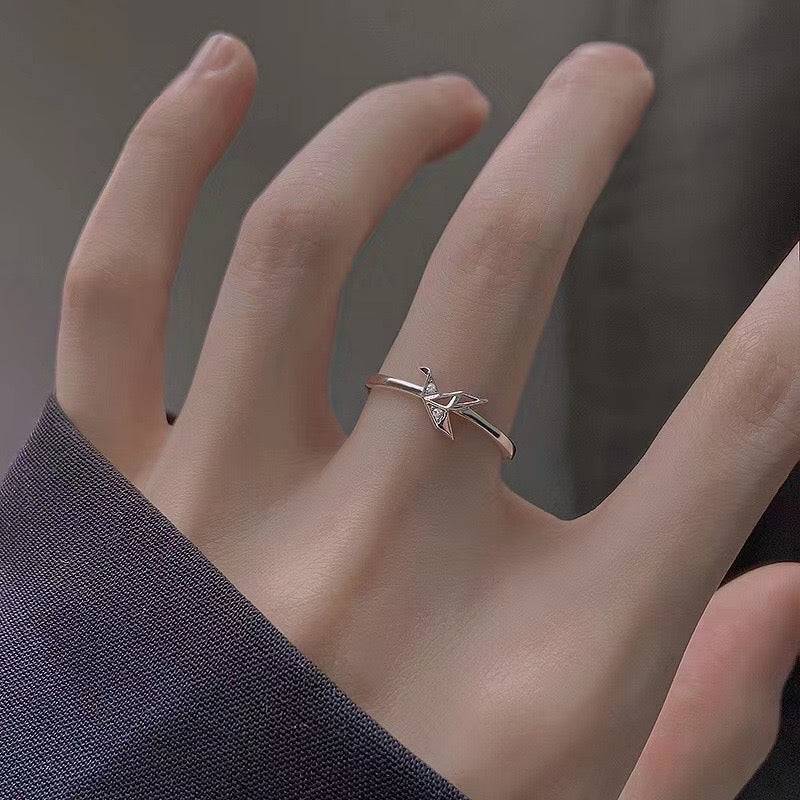 woman wearing silver ring with crane origami design