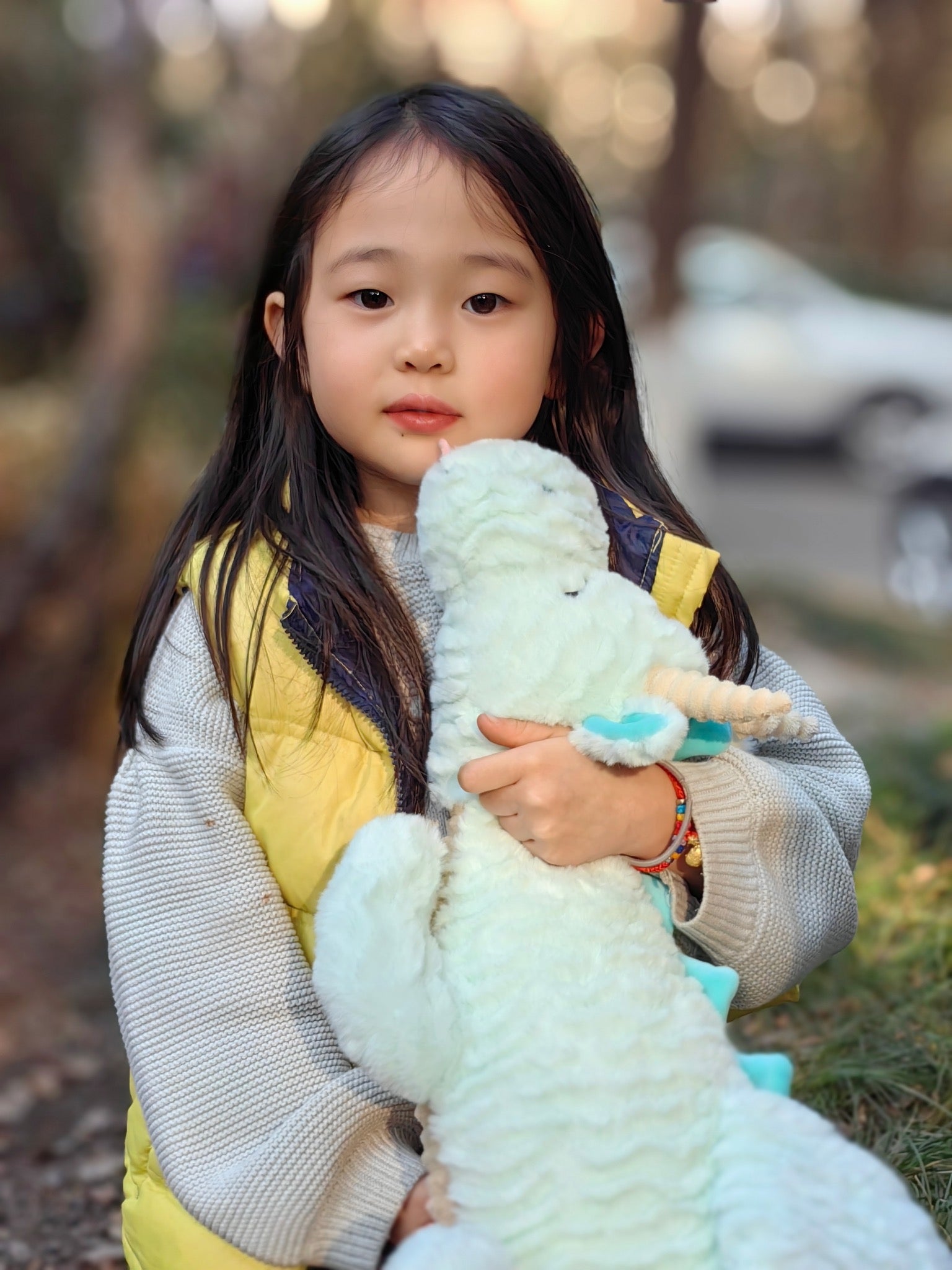 little girl hugging her dragon plushie