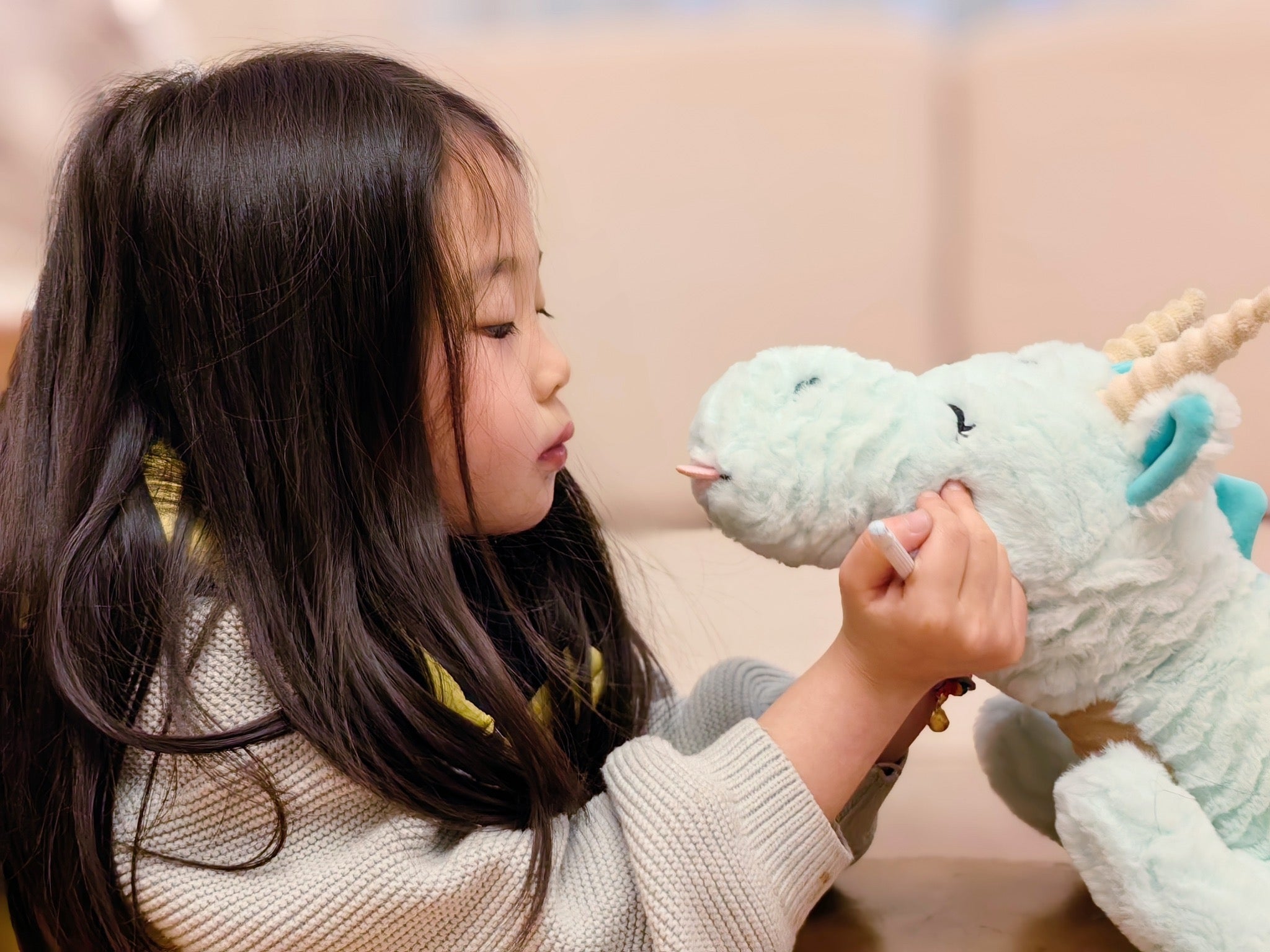 little girl looking her dragon plushie