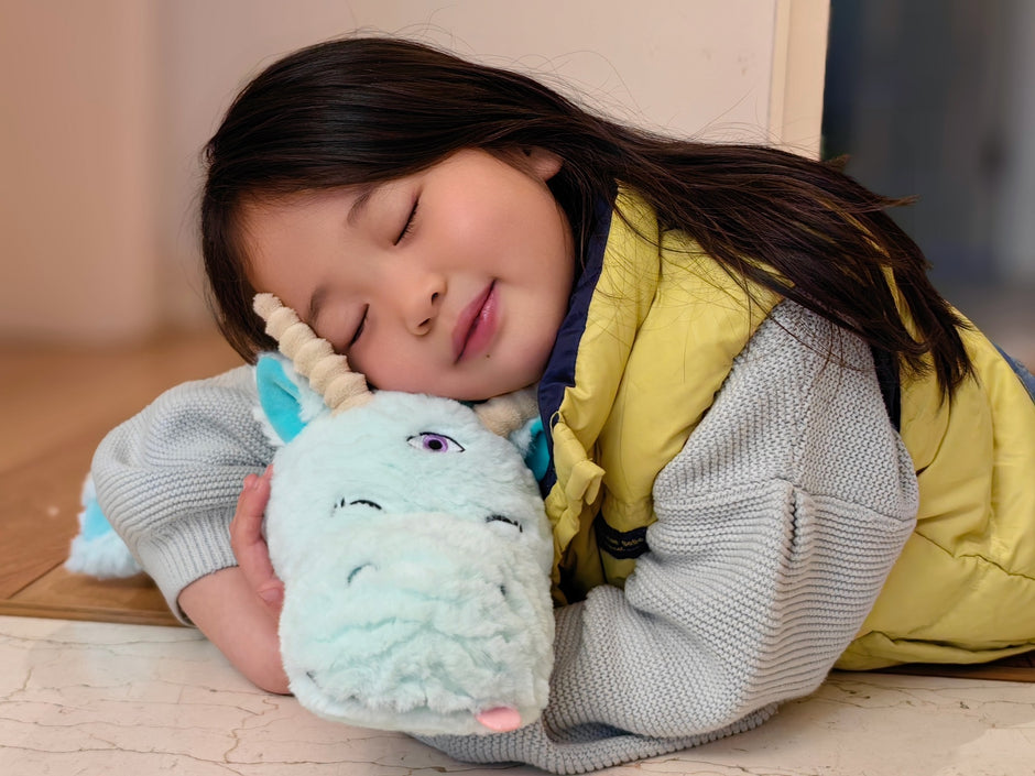 little girl hugging her dragon plushie